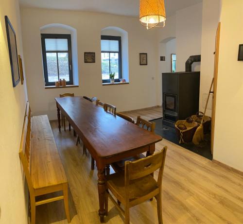 uma sala de jantar com uma grande mesa de madeira e cadeiras em Fasa Lodge em Kurort Oberwiesenthal