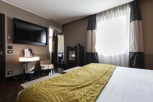 a hotel room with a bed and a flat screen tv at Rome Times Hotel in Rome