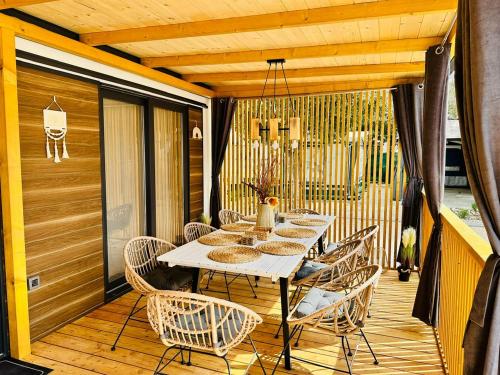 a wooden deck with a table and chairs on it at Brand New Mobile House - Soline Beach in Biograd na Moru