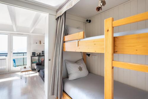 Ce lit superposé se trouve dans une petite chambre dotée d'un canapé. dans l'établissement Studio NATHEN - Parking - Wifi - Balcon Sud ouest - Chamrousse 1650, à Chamrousse