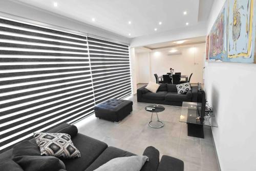 uma sala de estar com um sofá e uma mesa em Glabur Stays - The Luxurious 3 BDR - Cozy apt Newly Renovated, Nicosia City em Ayios Dhometios