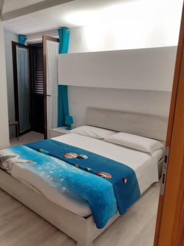 a bedroom with a bed with a blue blanket on it at VASTO centro Alloggio 1-2-3 in Vasto