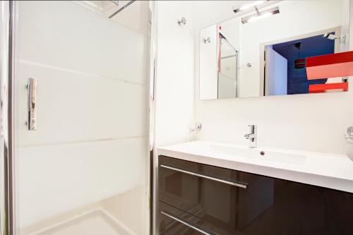 W łazience znajduje się umywalka i lustro. w obiekcie Sylvestre - Aux pieds des pistes vue sur lac w mieście Les Angles