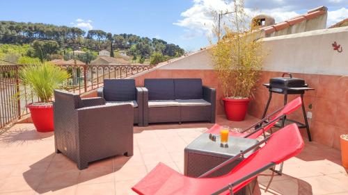 a patio with a couch and chairs and a grill at VILLA REIALA Plan-de-Cuques in Marseille