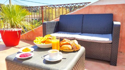 une table avec un petit-déjeuner composé de pain et de fruits sur un balcon dans l'établissement VILLA REIALA Plan-de-Cuques, à Marseille