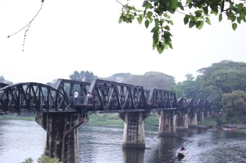 a bridge over a river with people on it at Kanchanaburi City Hotel in Kanchanaburi