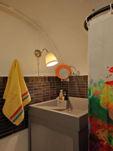 baño con lavabo y cortina de ducha en La tana di Topolino, en Imola