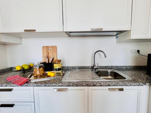 a kitchen counter with a sink and some fruit at The Sky of Cagliari in Cagliari