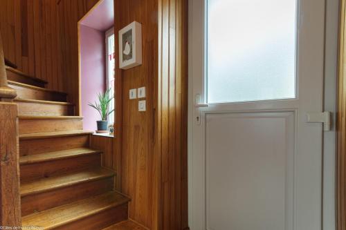 a door leading to a hallway with wooden stairs at ArPaMond in Château-Chinon