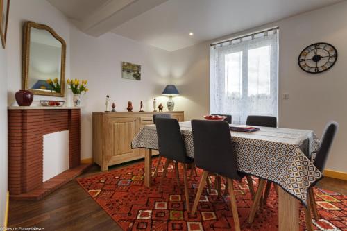 a dining room with a table and chairs and a mirror at ArPaMond in Château-Chinon