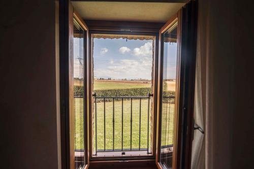 a room with a window with a view of a field at Fenil Conter Cottage & Suite in Pozzolengo