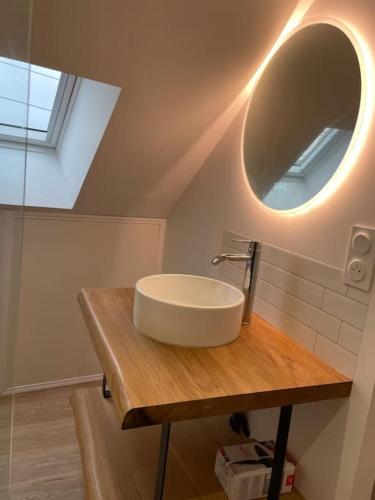 een badkamer met een wastafel en een spiegel bij Bryas 3 - Appartement très chaleureux in Châteauroux