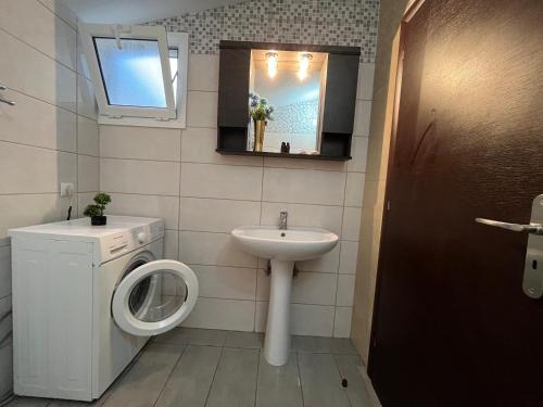 a bathroom with a washing machine and a sink at Anatoli deluxe house in Amoudi