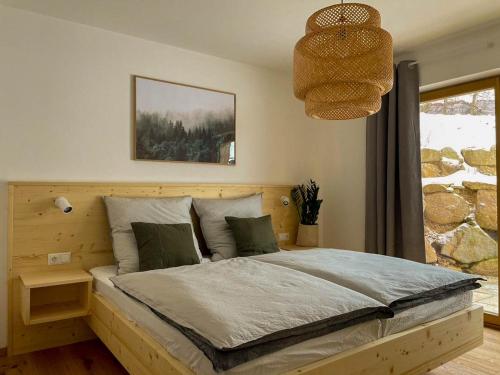 1 dormitorio con 1 cama grande en una habitación con ventana en Bayerwald Chalet Kaitersberg mit Sauna, Sonnenterrasse und Garten, en Arnbruck