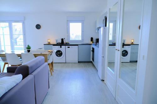 a living room with a couch and a kitchen at Double Apparts - Spacieux 140 m2 - 4 Ch - Entrée autonome- 2 Parkings Privé Gratuit in Melun