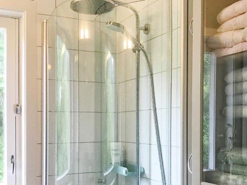a shower with a glass door in a bathroom at Holiday home SORTLAND III in Sortland