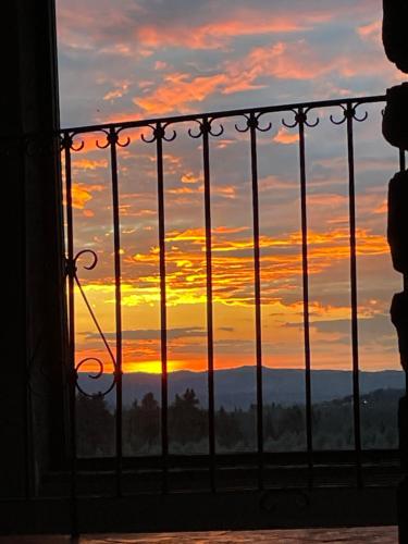a sunset view from a balcony with a fence at Torre Di Ponzano in Barberino di Val dʼElsa