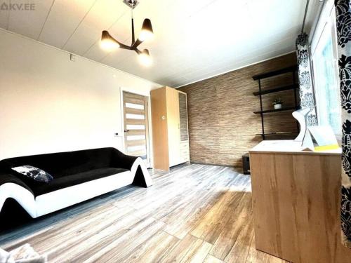 a bedroom with a black and white bed and wooden floors at Rentida luxuslik maja. in Tallinn