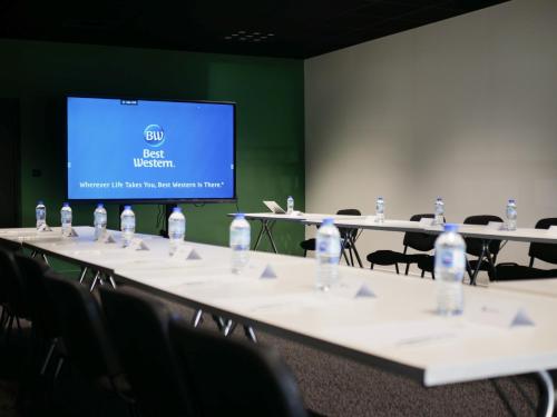 a conference room with tables and chairs with water bottles at Best Western Le Bois de la Marche in Poitiers