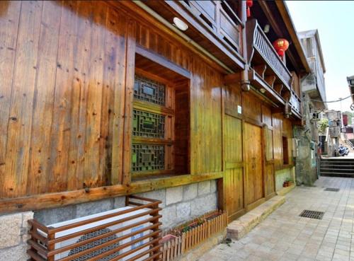 un edificio de madera con un banco delante de él en 小島上二館, en Chung-liu-ts'un