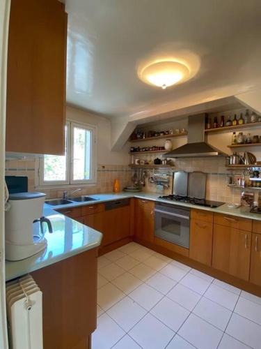 Il comprend une cuisine avec des placards en bois et du carrelage blanc. dans l'établissement Villa La Terrasse, à Villefranche-sur-Mer