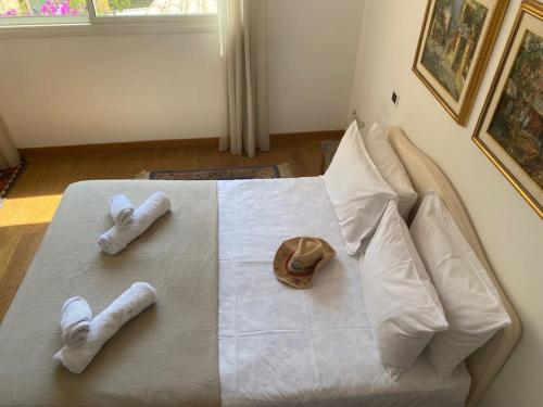 - un lit avec 2 serviettes et un chapeau dans l'établissement Villa La Terrasse, à Villefranche-sur-Mer