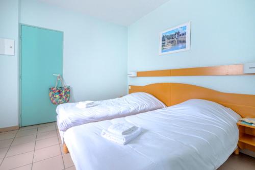 a bedroom with two beds with white sheets at Village Club Les Balcons des Pyrénées in Saint-Mamet