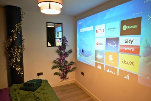 Zimmer mit einem großen Bildschirm an der Wand in der Unterkunft NEW Luxury NYC Style Loft with Cinema Room in Bradford