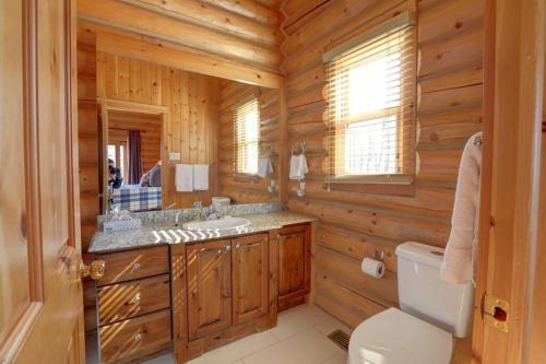 ein Holzbadezimmer mit einem Waschbecken und einem WC in der Unterkunft Fiddler Lake Resort Chalet 96 Elk in Mille-Isles
