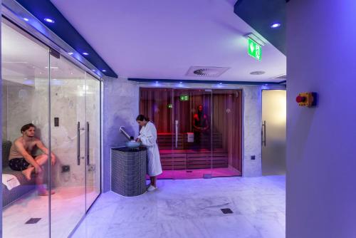 a woman standing in a bathroom with a shower at Brotherton House in Leeds in Leeds