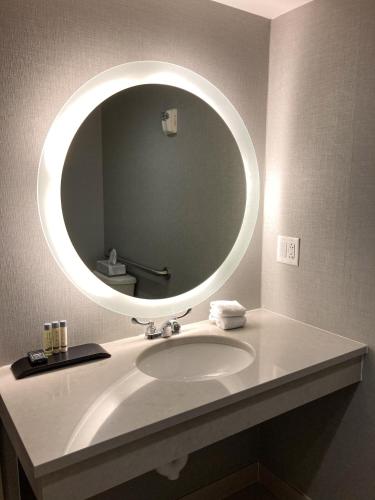 a bathroom with a sink with a round mirror at Toftrees Golf Resort in State College