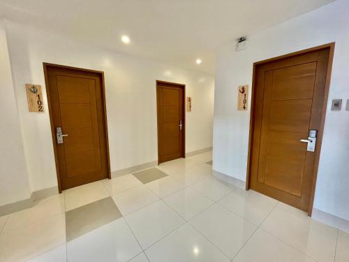 a hallway with two wooden doors in a building at Lighthouse Point Hotel in Dumaguete