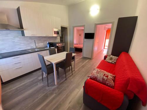 ein Wohnzimmer mit einem roten Sofa und einer Küche in der Unterkunft Il Nido in Gonnesa