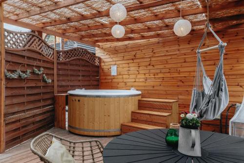 - un sauna avec une baignoire, une table et des chaises dans l'établissement Apartament z antresolą, à Okszów