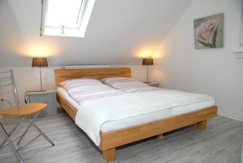 łóżko w pokoju z 2 lampami i stołem w obiekcie Seeschwalbe w mieście Scharbeutz