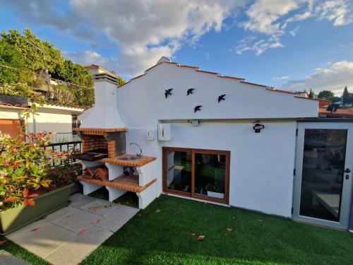 a white house with birds on the roof at Casa dos Avós - Folgosa Douro in Folgosa