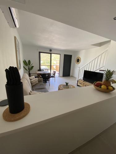 a kitchen and living room with white walls and ceilings at Cottage Cosy Duplex Anse Marcel, Vue mer et marina in Anse Marcel 