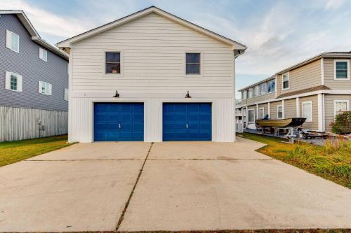 a white house with two garage doors in a driveway at 47 Oyster Bay Dr in Fenwick Island