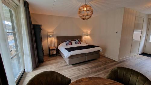 a bedroom with a bed and a chandelier at B&B De Droomhoeve in Nunspeet