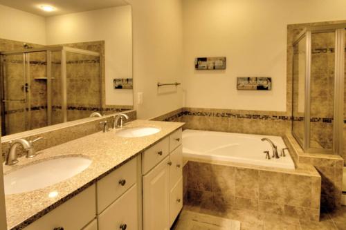 a bathroom with two sinks and a bath tub at 38815 Cedar Waxwing La Bay Forest Bethany in Ocean View