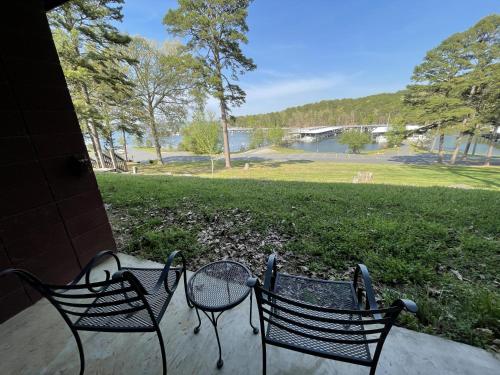 two chairs and a table with a view of a park at Mountain Harbor Queen Guest Room on Lake Ouachita in Mount Ida