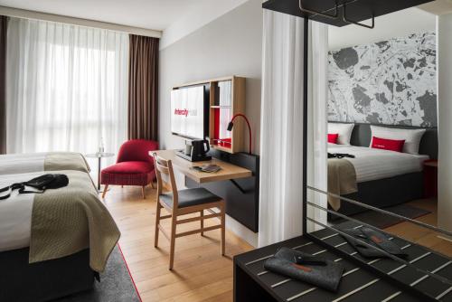 Habitación de hotel con cama y escritorio con ordenador en IntercityHotel Karlsruhe en Karlsruhe