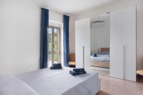 um quarto branco com uma cama e um espelho em Da Chicca em Bolano