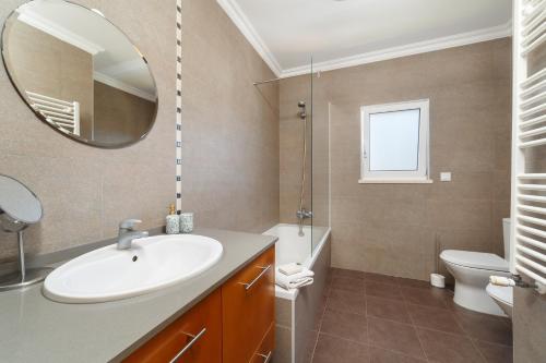 La salle de bains est pourvue d'un lavabo, d'un miroir et de toilettes. dans l'établissement Casa da Baleia, à Foz do Arelho