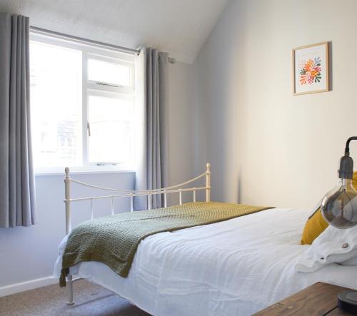 a white bedroom with a bed and a window at IndieHaus in Lincolnshire