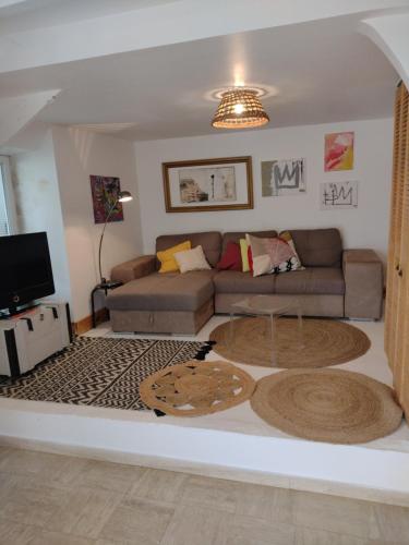 een woonkamer met een bank en een tv bij L'ermitage in Agen