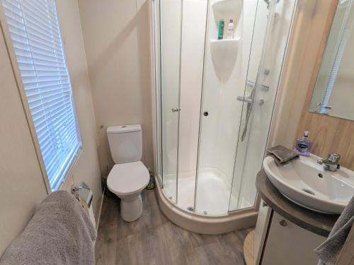 a bathroom with a shower and a toilet and a sink at Mollys Lodge in Ryde