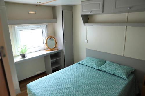 1 dormitorio con 1 cama con edredón azul y ventana en AquaHause, en Pataias