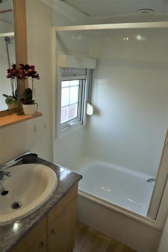 a bathroom with a sink and a bath tub with a window at AquaHause in Pataias