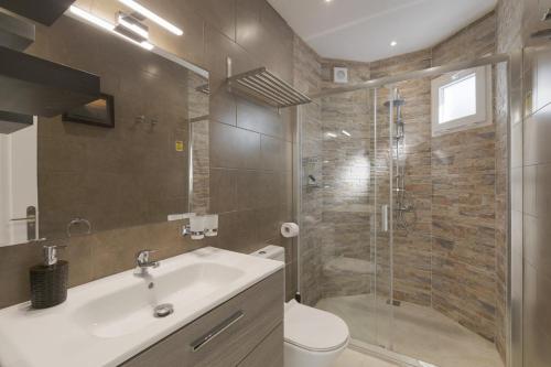 een badkamer met een douche, een wastafel en een toilet bij Stunning Apartment - Near Los Cristianos in Chayofa